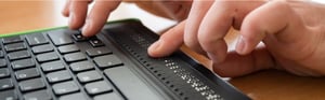 close up of a hands using a braille display